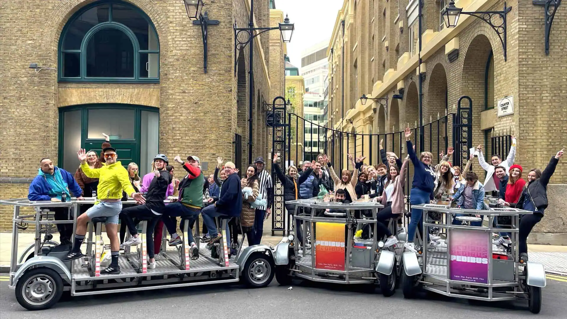 Large group riding multiple Pedibus party bikes (beer bikes) in London